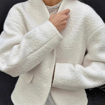 Person wearing a white textured jacket with a blurred background