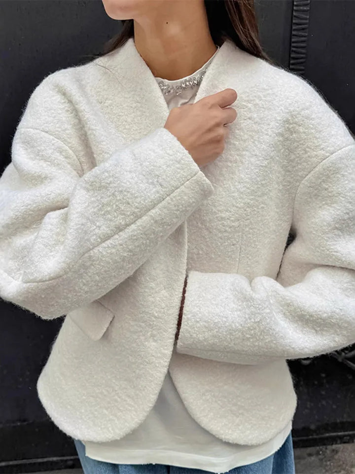 Person wearing a white textured jacket with a blurred background