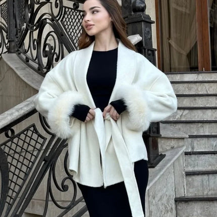 Woman wearing a white fur-trimmed coat on a staircase