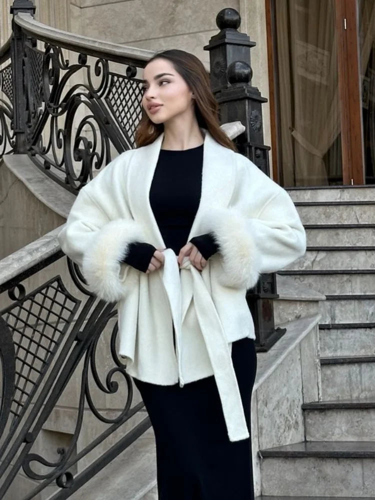 Woman wearing a white fur-trimmed coat on a staircase