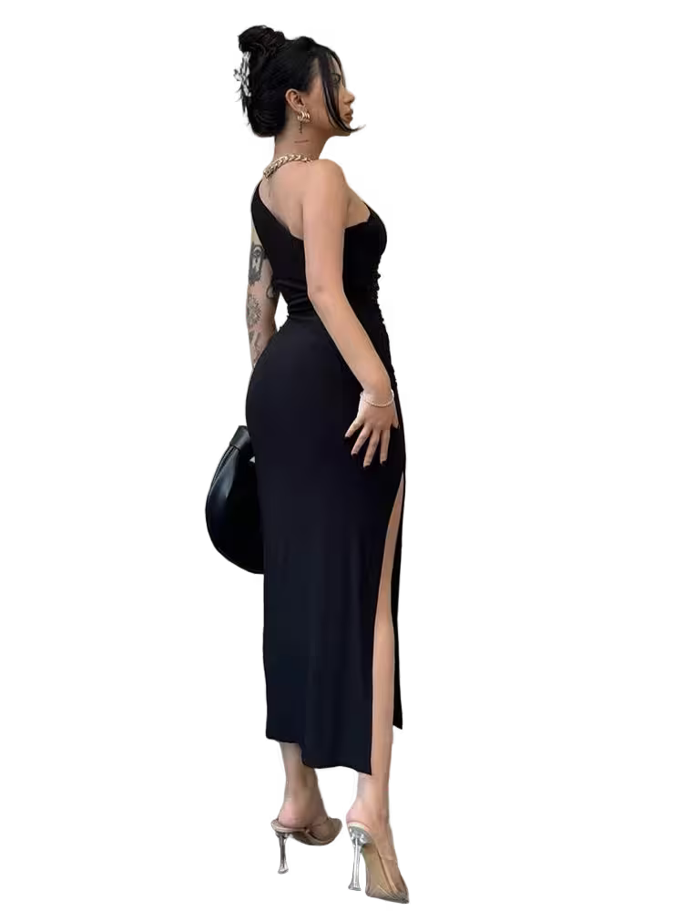Woman in a black evening gown with a high slit, holding a black handbag.