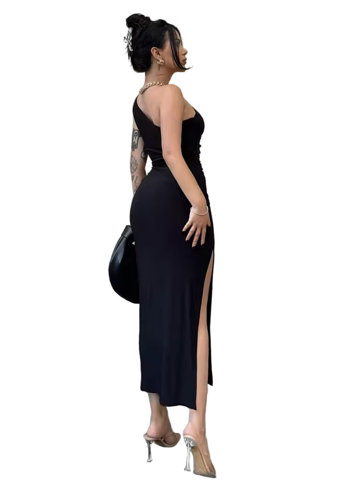 Woman in a black evening gown with a high slit, holding a black handbag.