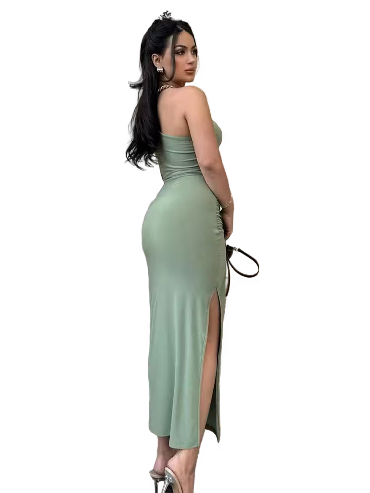 Woman wearing a green strapless dress with a slit on a white background