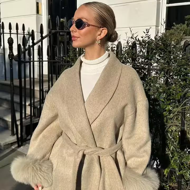 Woman wearing a beige coat with fur trim in an urban setting