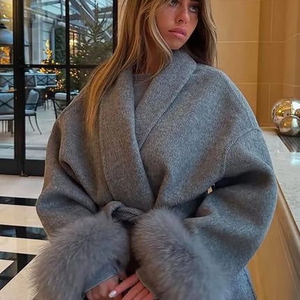 Woman wearing a gray coat with fur trim indoors