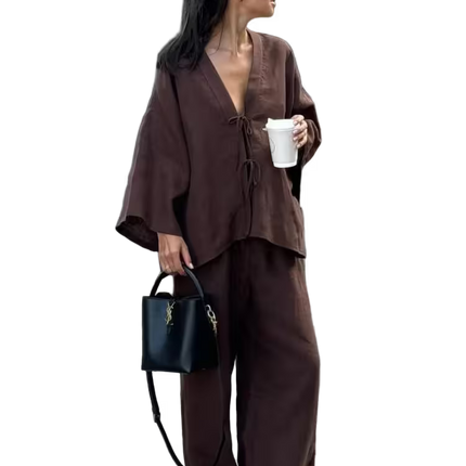 Woman in a brown outfit holding a black handbag and white cup on a transparent background