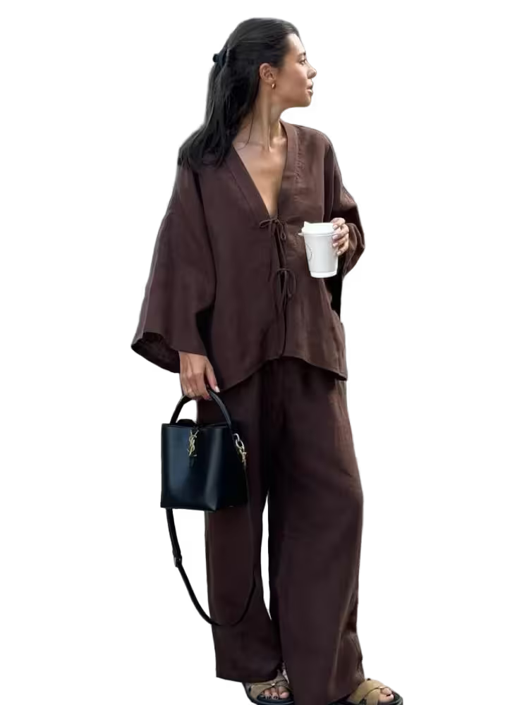 Woman in a brown outfit holding a black handbag and white cup on a transparent background