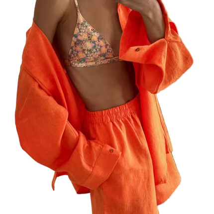 Person wearing a floral bikini top and orange shorts with jacket on a transparent background