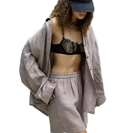 Person wearing a black lace bralette, gray shorts, and a gray shirt with a blue cap on a transparent background.