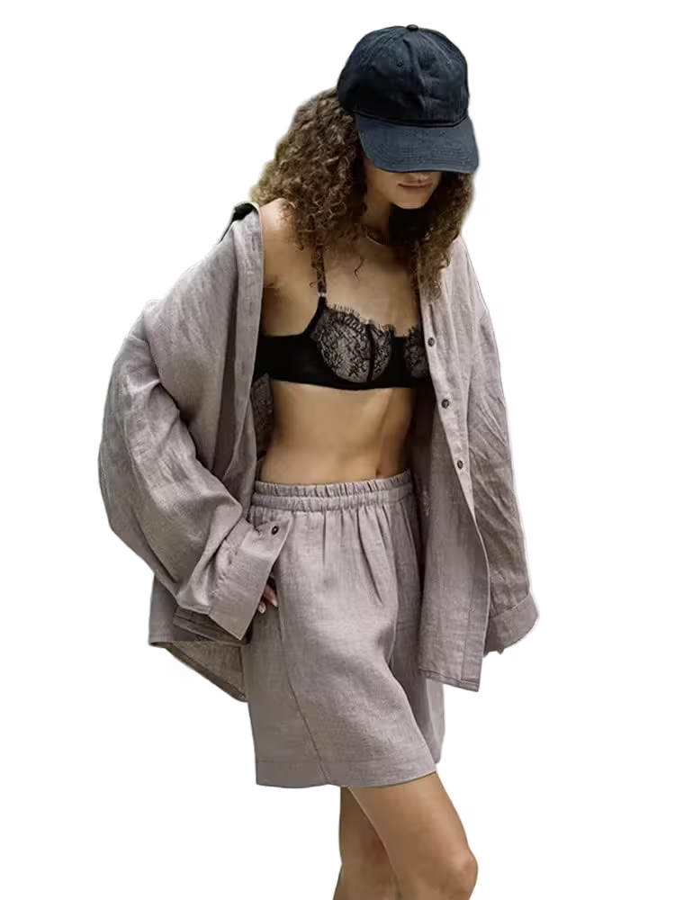 Person wearing a black lace bralette, gray shorts, and a gray shirt with a blue cap on a transparent background.