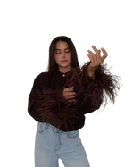 Woman wearing a brown textured sweater and light blue jeans on a transparent background