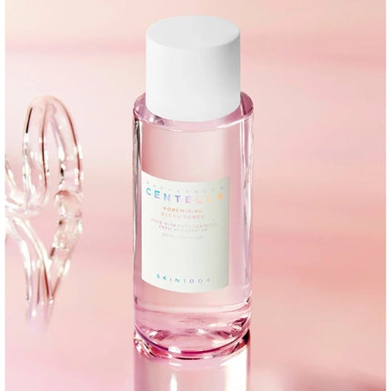 Pink skincare bottle with white cap on a gradient pink background