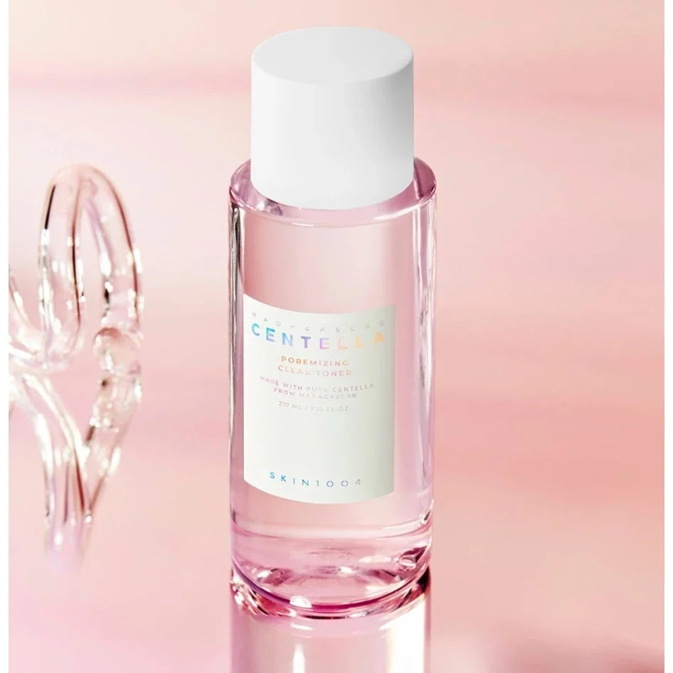 Pink skincare bottle with white cap on a gradient pink background