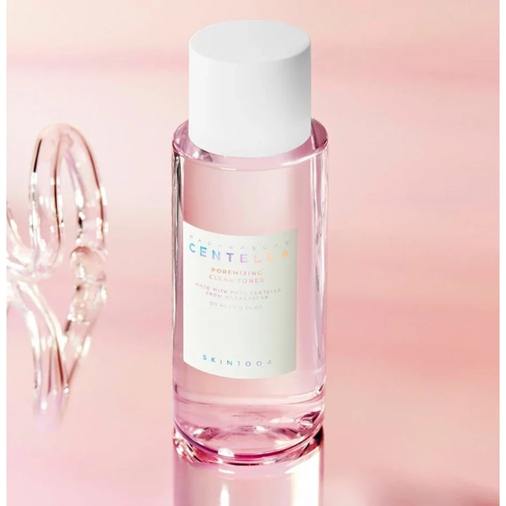 Pink skincare bottle with white cap on a gradient pink background