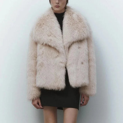 Person wearing a fluffy beige jacket against a white background