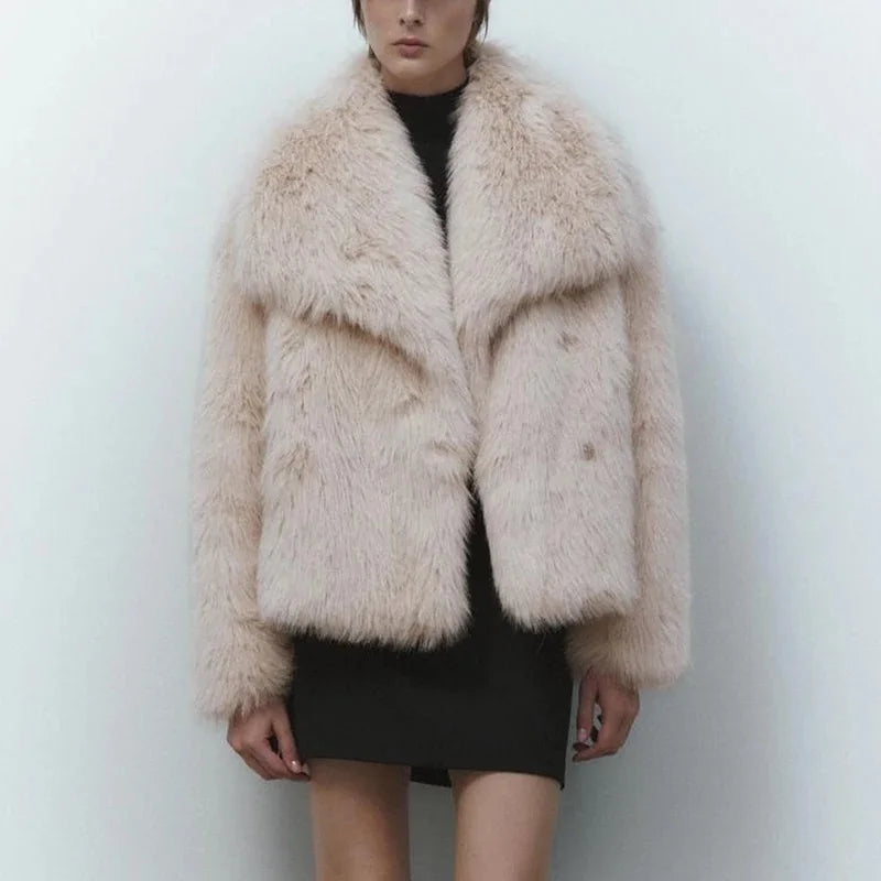 Person wearing a fluffy beige jacket against a white background