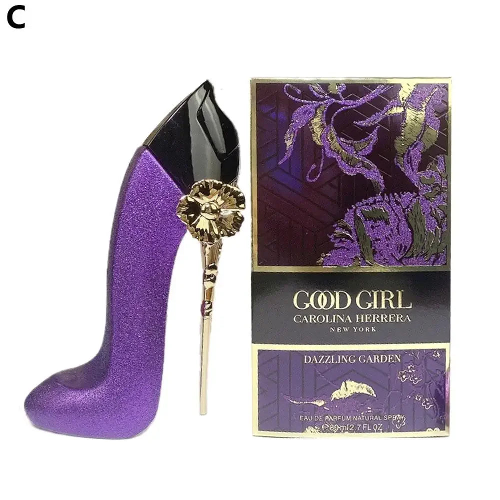 Purple high-heeled shoe and 'Good Girl' Carolina Herrera perfume box on a white background