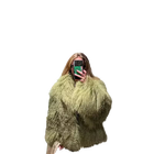 Person wearing a fluffy green coat against a white background