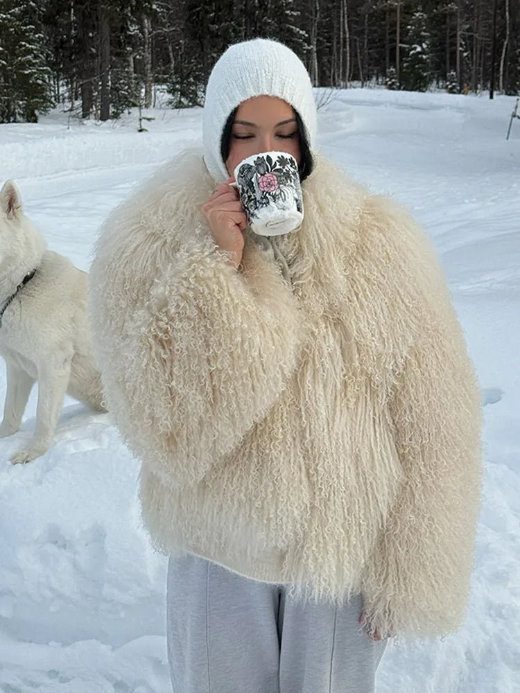 Person in a fluffy white coat holding a mug in a snowy landscape with a dog.