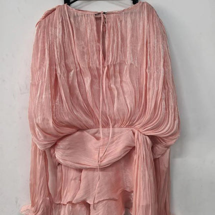 Pink sheer top on a hanger against a white background