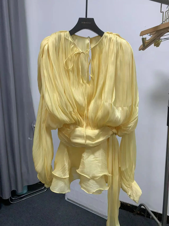 Yellow outfit on a hanger against a white wall
