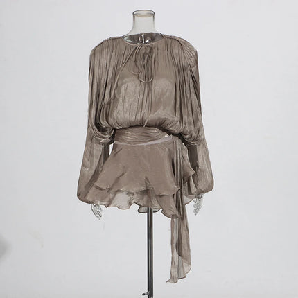 Sheer beige blouse and skirt set on a mannequin against a white background