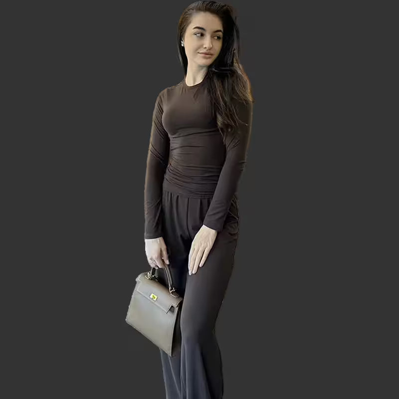 Woman holding a gray handbag against a dark background