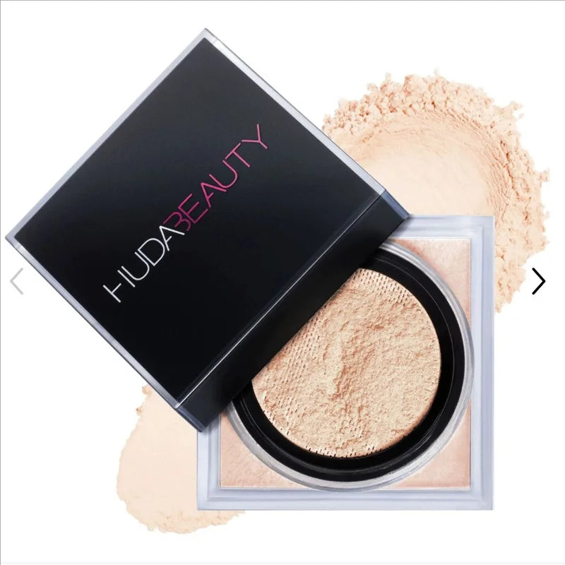 Huda Beauty powder compact with open lid showing light beige powder on a white background