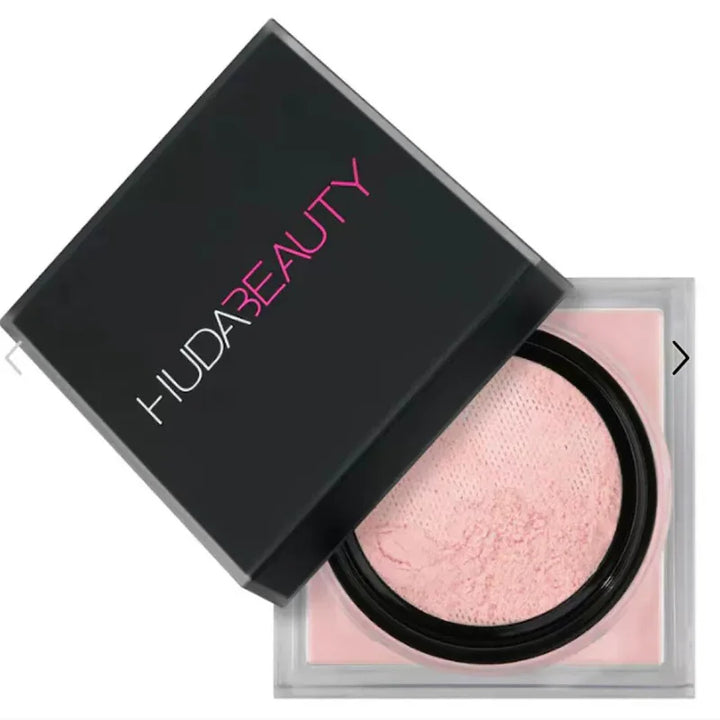 Huda Beauty compact with pink powder on a white background