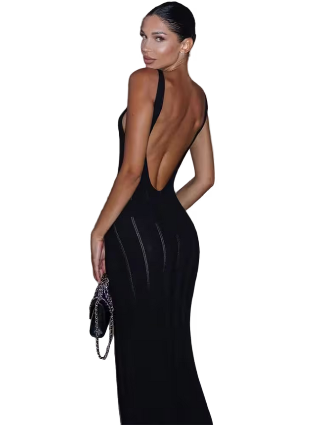 Woman wearing a black evening gown with a low back design, holding a clutch.