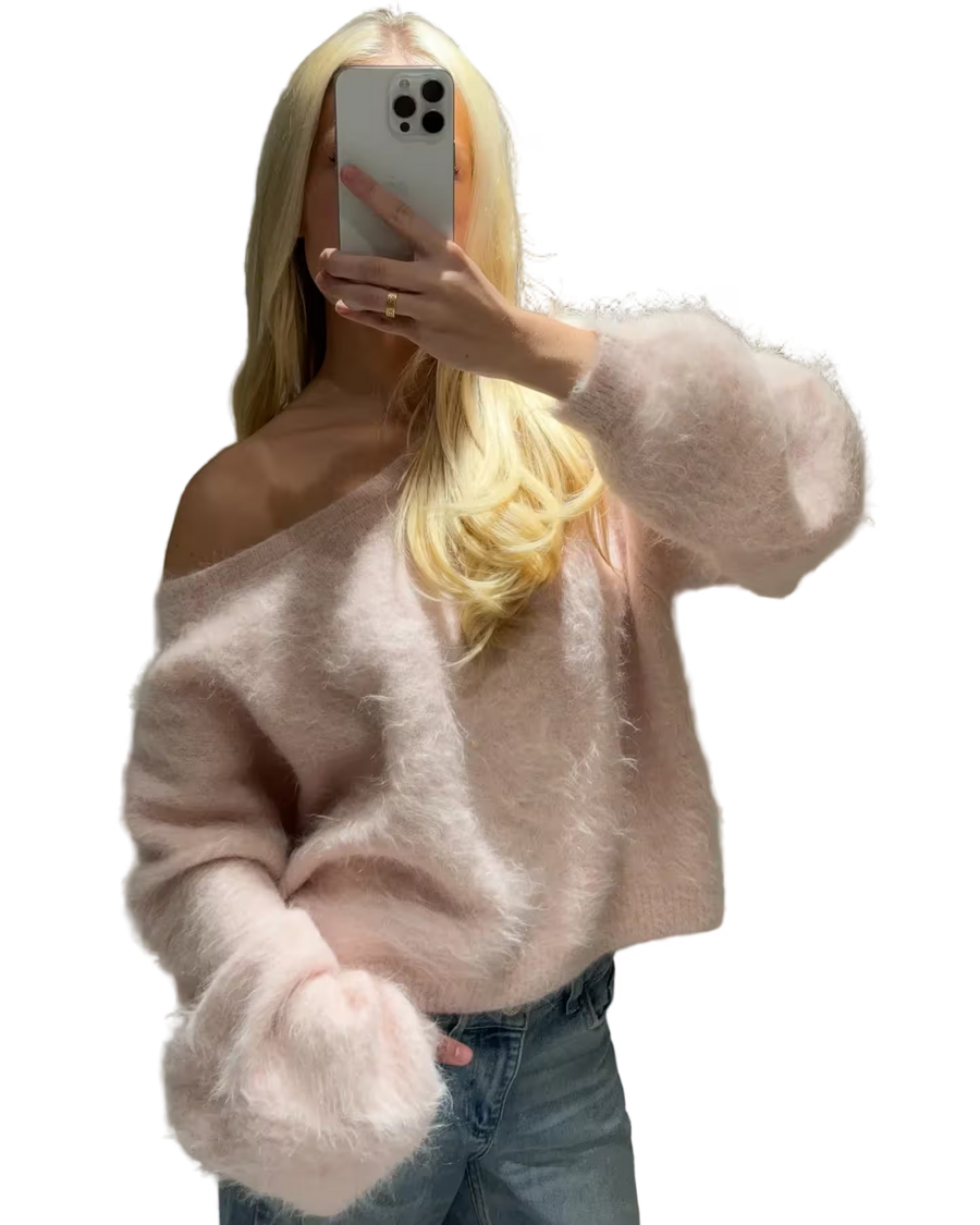 Person wearing a light pink sweater and blue jeans, holding a phone with a transparent background