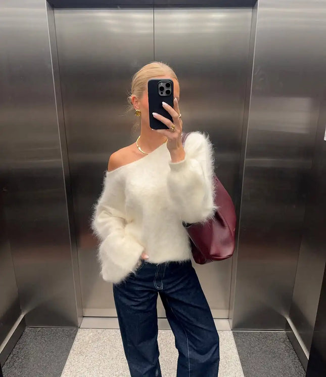 Person wearing a white fluffy sweater and dark jeans in an elevator.