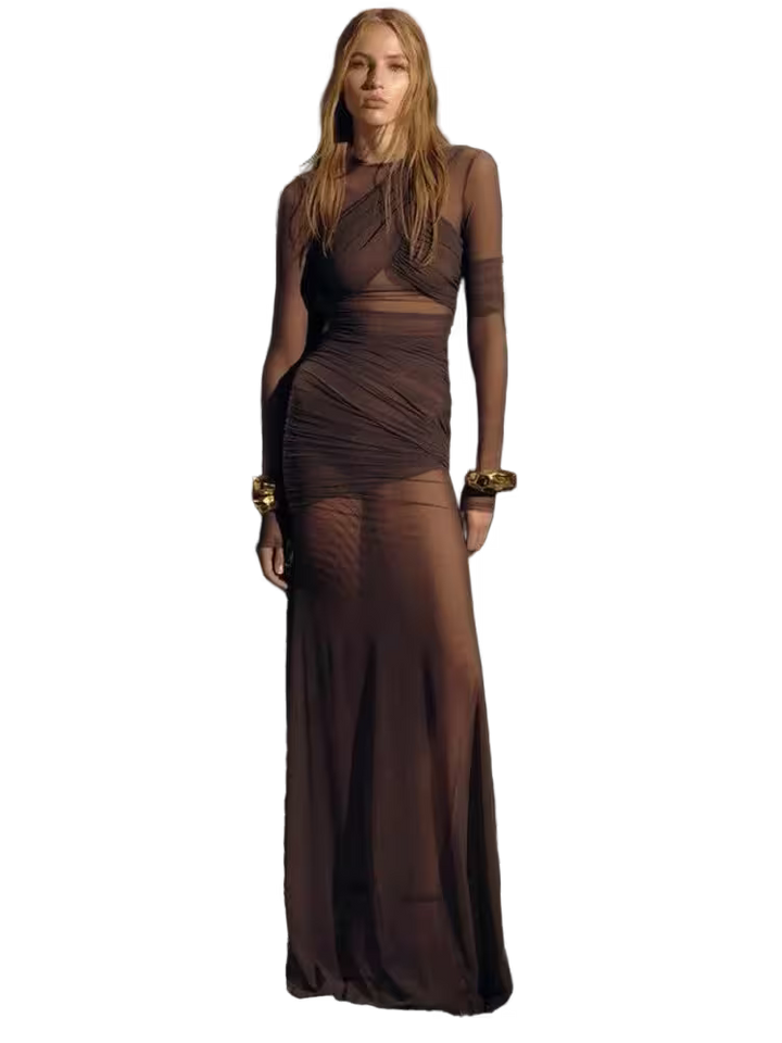 Woman wearing a brown dress with sheer panels on a white background