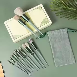 Set of makeup brushes with a pouch on a green surface