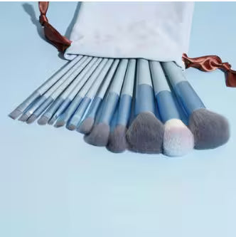 Set of makeup brushes with a white pouch on a light blue background