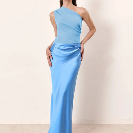 Woman wearing a light blue one-shoulder gown against a plain background