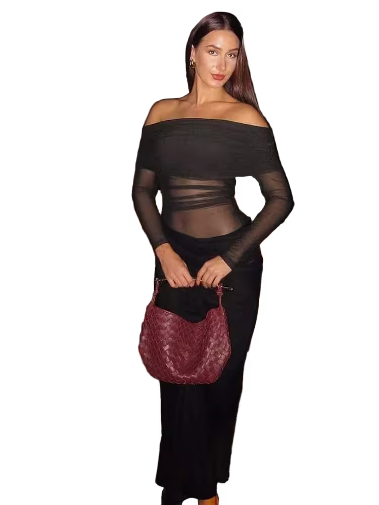 Woman holding a maroon handbag against a white background