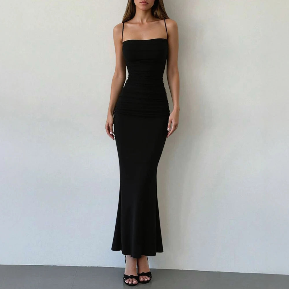 Woman wearing a black strapless dress against a plain background