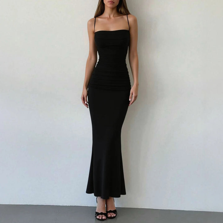 Woman wearing a black strapless dress against a plain background