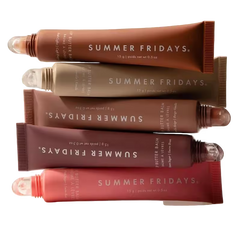 Stack of Summer Fridays butter balm tubes in various shades on a white background