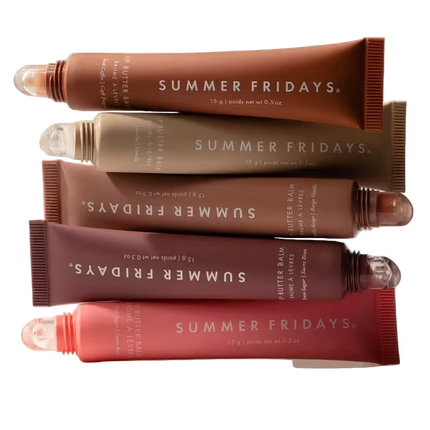 Stack of Summer Fridays butter balm tubes in various shades on a white background