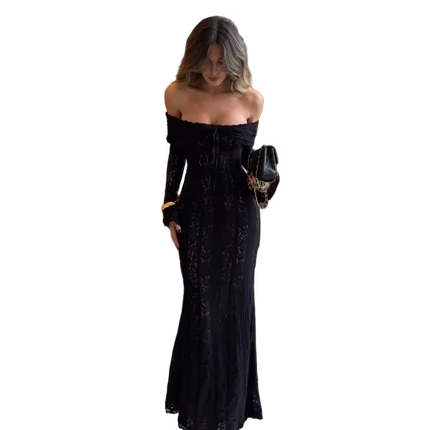 Woman wearing a black off-shoulder dress holding a black clutch against a white background