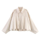Beige cape-style jacket on a white background